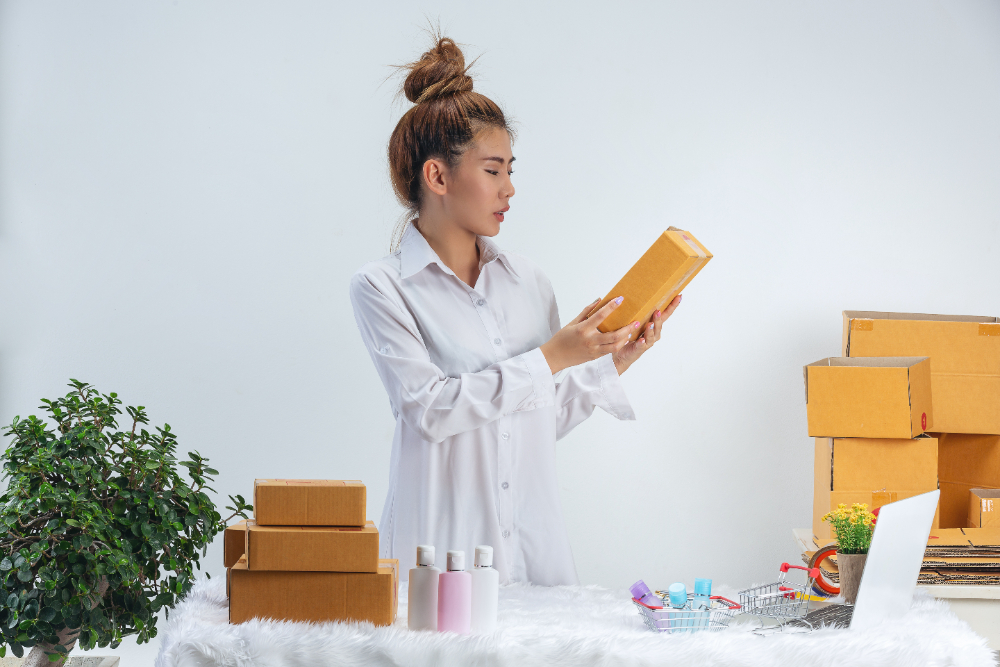 A business woman is working online and traing to reply customer at home office packaging on wall.