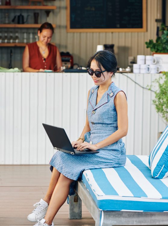 beautiful female expert freelancer doing local seo for hotel while sitting outside so that she can pin exact location