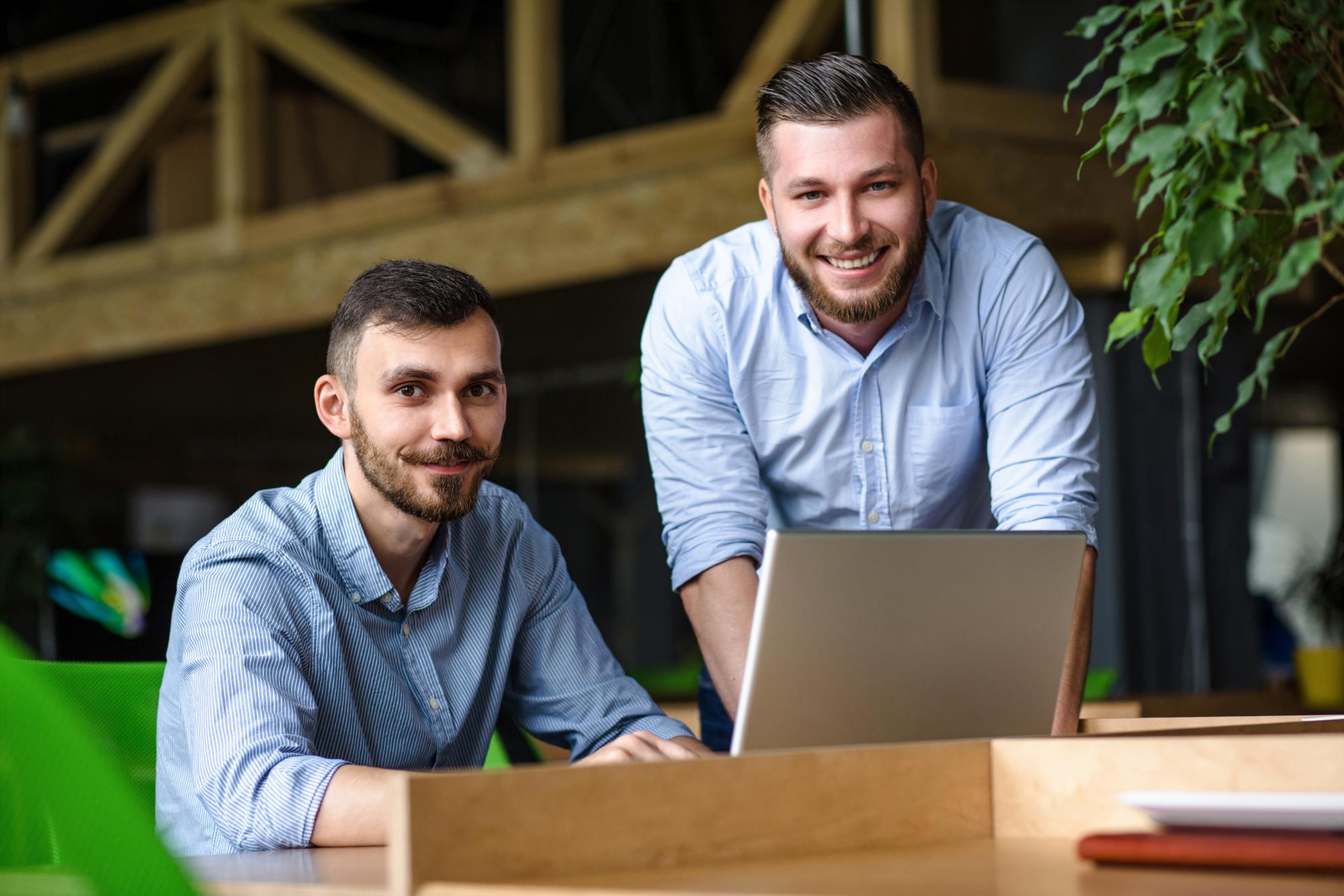 picture-handsome-businessman-listening-his-colleague-partner-concerning-ner-business-system-while-working-laptop-computer-office-interior.j