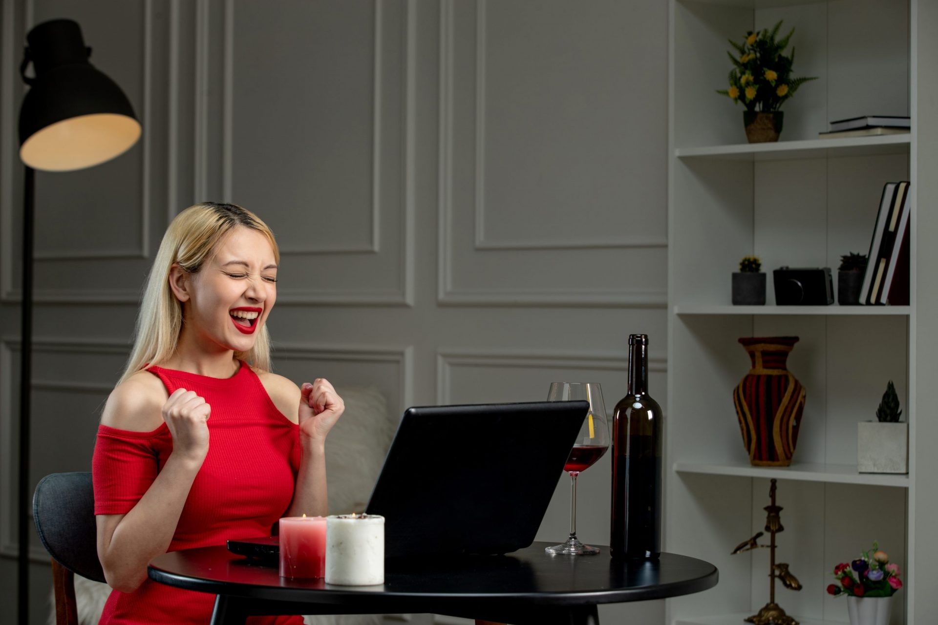 Virtual love blonde girl in red dress on distance date with wine excited