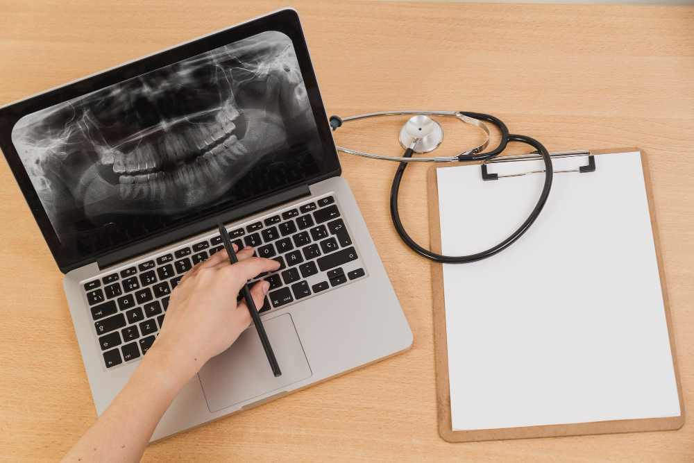 x-ray displayed on laptop screen while doctor examining it on dental website designed for hospitals