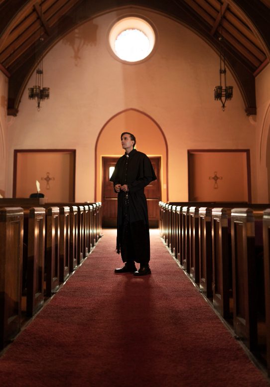 man standing in the church while a photographer taking his photo for churcch website about page designing