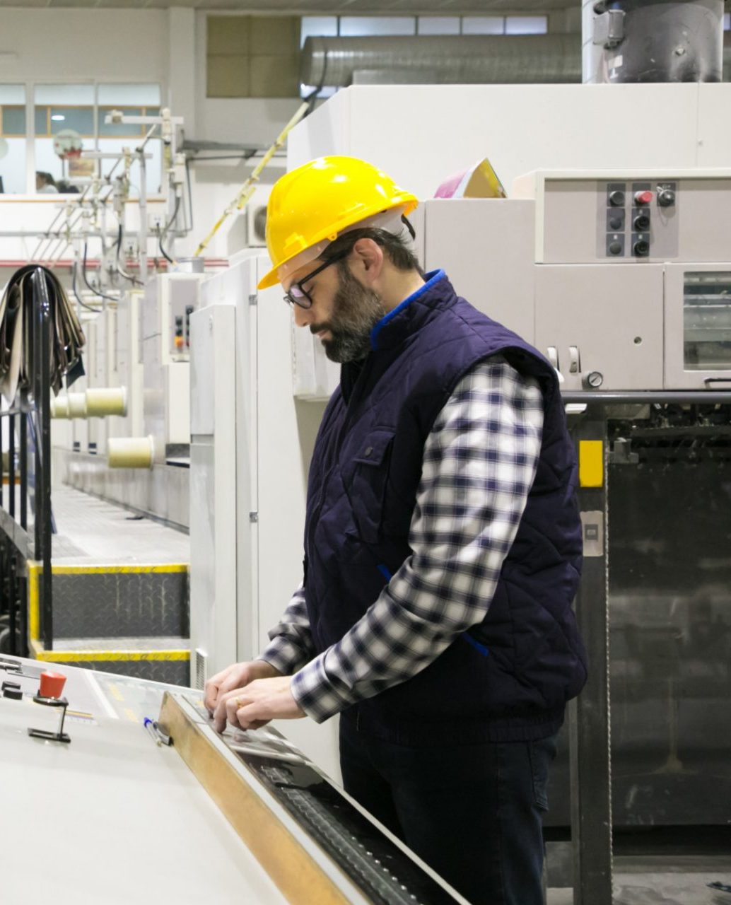 Focused male engineer in glasses operating machine of anufacturing website design